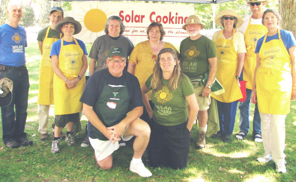 Doran Smout wearing a green shirt and khaki hat participating in a Solar Cookers International solar cooking demonstration