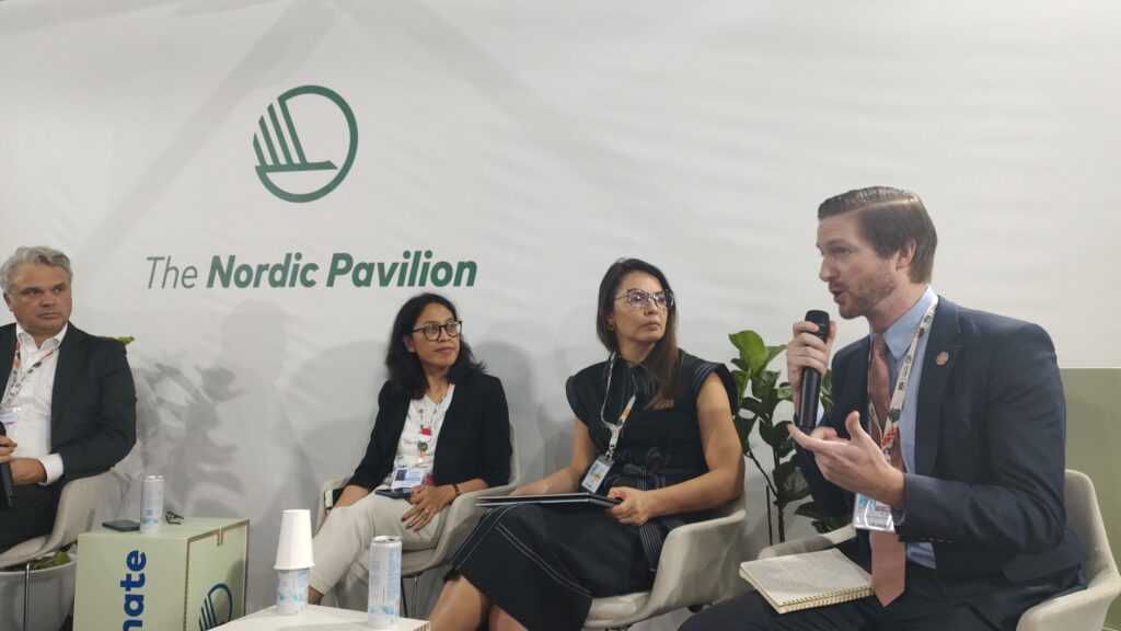Panelists speaking during a COP30 session on climate security and solar technology