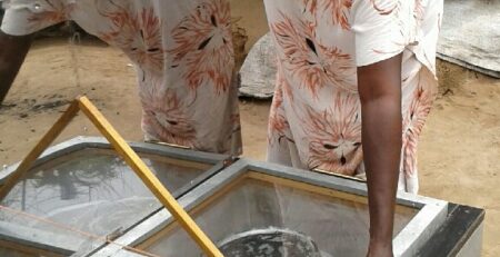Family using a solar cooker in Kakuma Refugee Camp, Kenya for clean and sustainable cooking