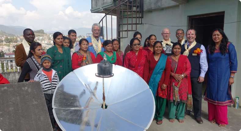 Family using a solar cooker in a remote community in Nepal