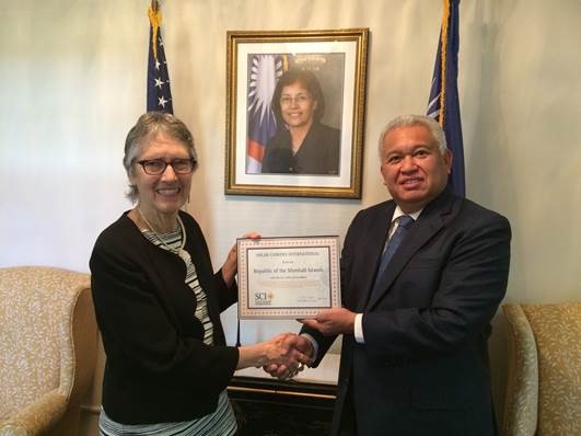 Dr. Peg Barratt presenting Solar Cookers International Order of Excellence award to Marshall Islands Ambassador Gerald Zackios