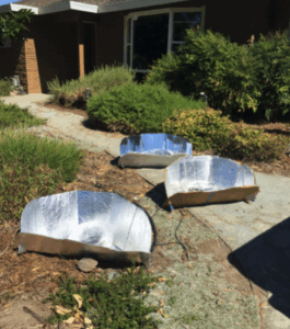 SCI supporter Maria preparing solar baked chicken using a solar cooker in Sacramento, California