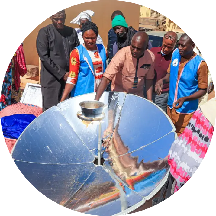 Women using locally made solar cookers during a community training session in Mali