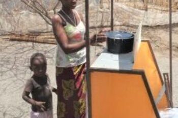 Elizabeth and her son benefiting from solar cooking through SCI's clean cooking initiatives