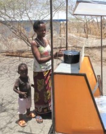 Mother Elizabeth and her son with a solar cooker supported by Solar Cookers International