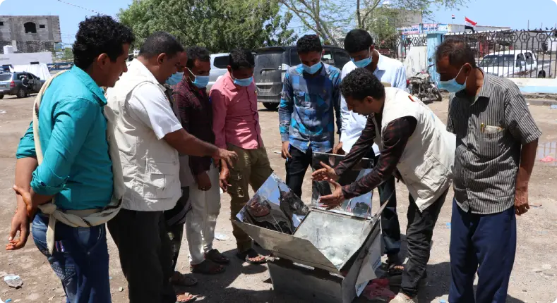 Community members using solar cookers and solar food dryers in Yemen