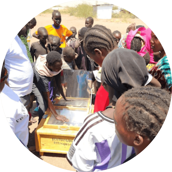 Rebecca demonstrating how to use a solar cooker during a community training session