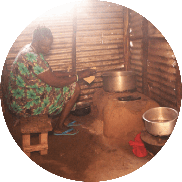 Woman cooking over a smoky wood fire in a traditional outdoor kitchen
