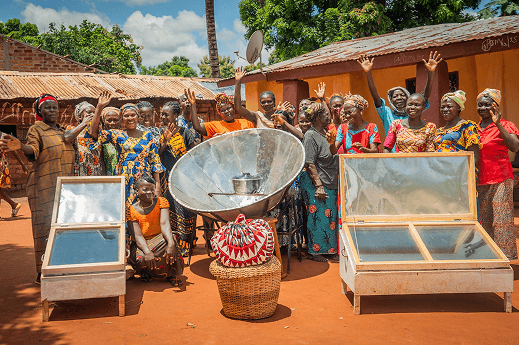 Community members gathered around a solar cooker during a hands-on training session