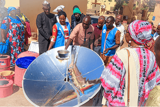 Participants gathered around a solar cooker during a hands-on training session in Mali
