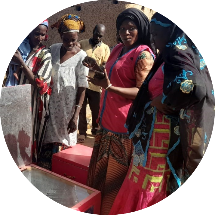 Women and young people participating in a solar cooking training session
